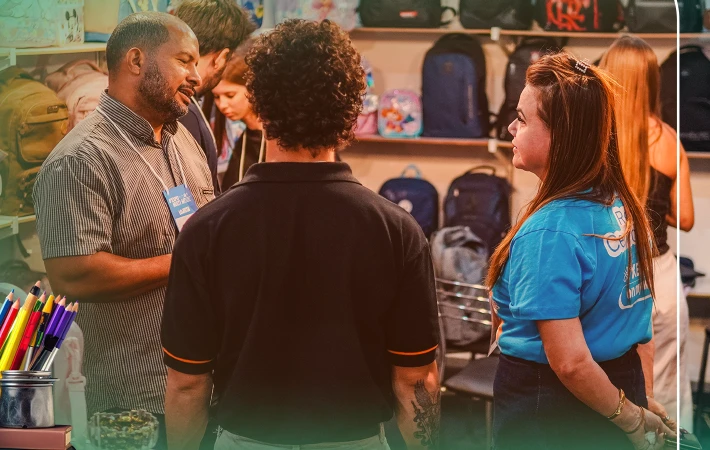 Representantes e visitantes conversam em estande da EXPOMULTI